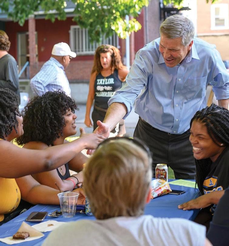 Chancellor shaking hands at block party